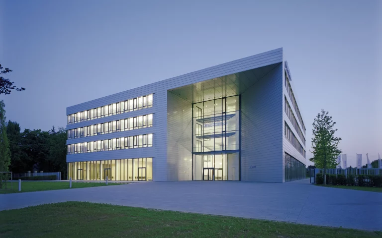 Neubau Altana Headquarter in Wesel Ansicht von Südosten mit baukörperhohem Haupteingang in der Dämmerung.