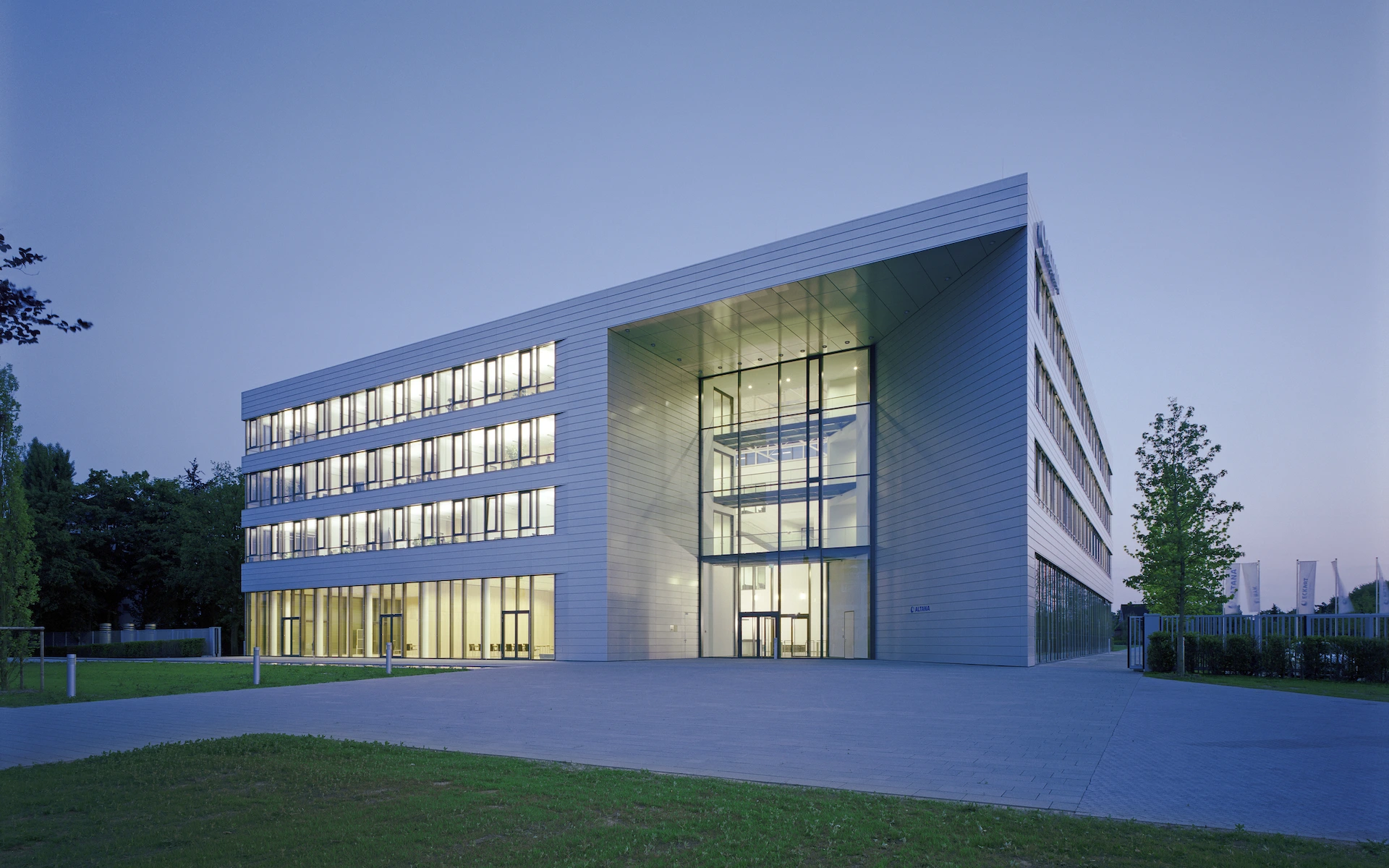 Neubau Altana Headquarter in Wesel Ansicht von Südosten mit baukörperhohem Haupteingang in der Dämmerung.
