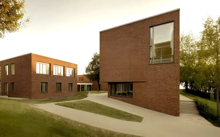 Erweiterung und Sanierung Hövelschule Essen Perspektive mit Eingang, Auffahrt, Schulhof, Außenanlagen, Klinkerfassade, Mensa, Klassenräumen und Lehrerzimmer.