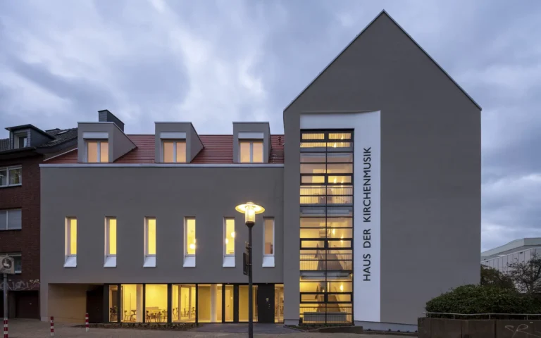 Umbau Haus der Kirchenmusik Essen Ansicht mit Eingangsfassade gegenüber dem Rathaus, mineralischem Putz, neuem Giebel und Schriftzug.