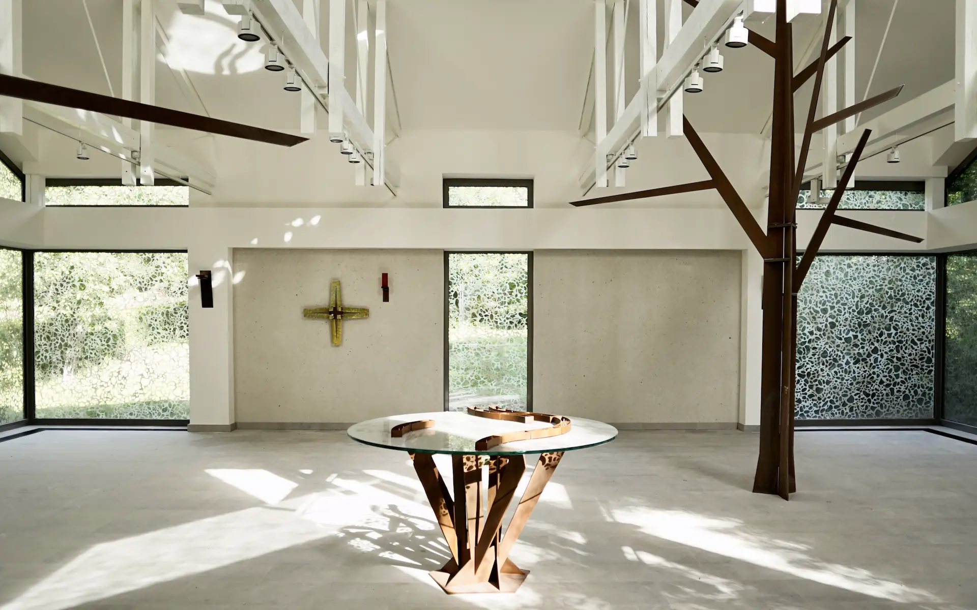 Umbau St. Altfrid in Essen Innenaufnahme vom Kirchenraum mit Altar, Kreuz, ewigem Licht, Ornamentglas, Eckfenstern, Cortenstahl-Bäumen und Holztragwerk.