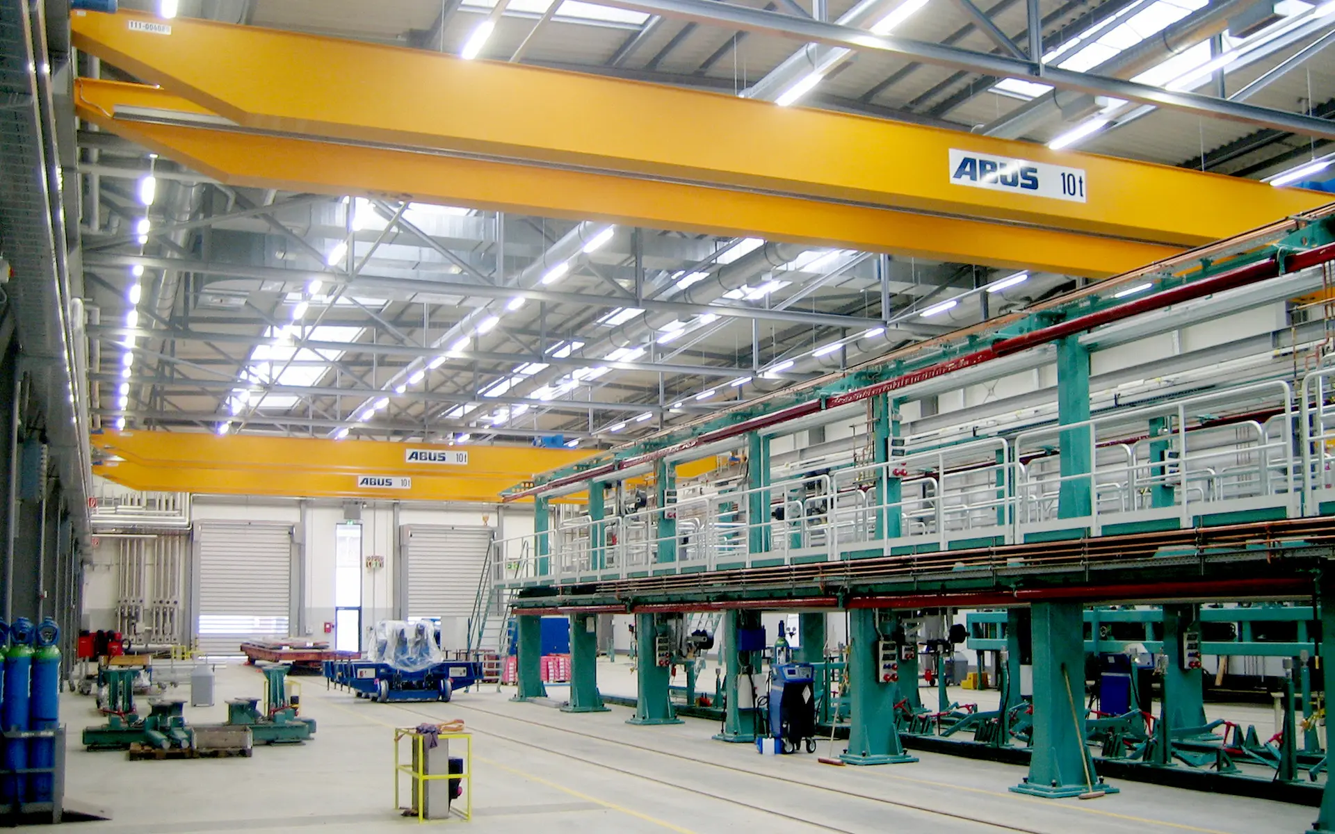 Neubau Siemens Halle 19 Krefeld Innenraum mit Arbeitsständen, Doppelkrananlagen, Gleisen im kopfversiegelten Industrieboden.