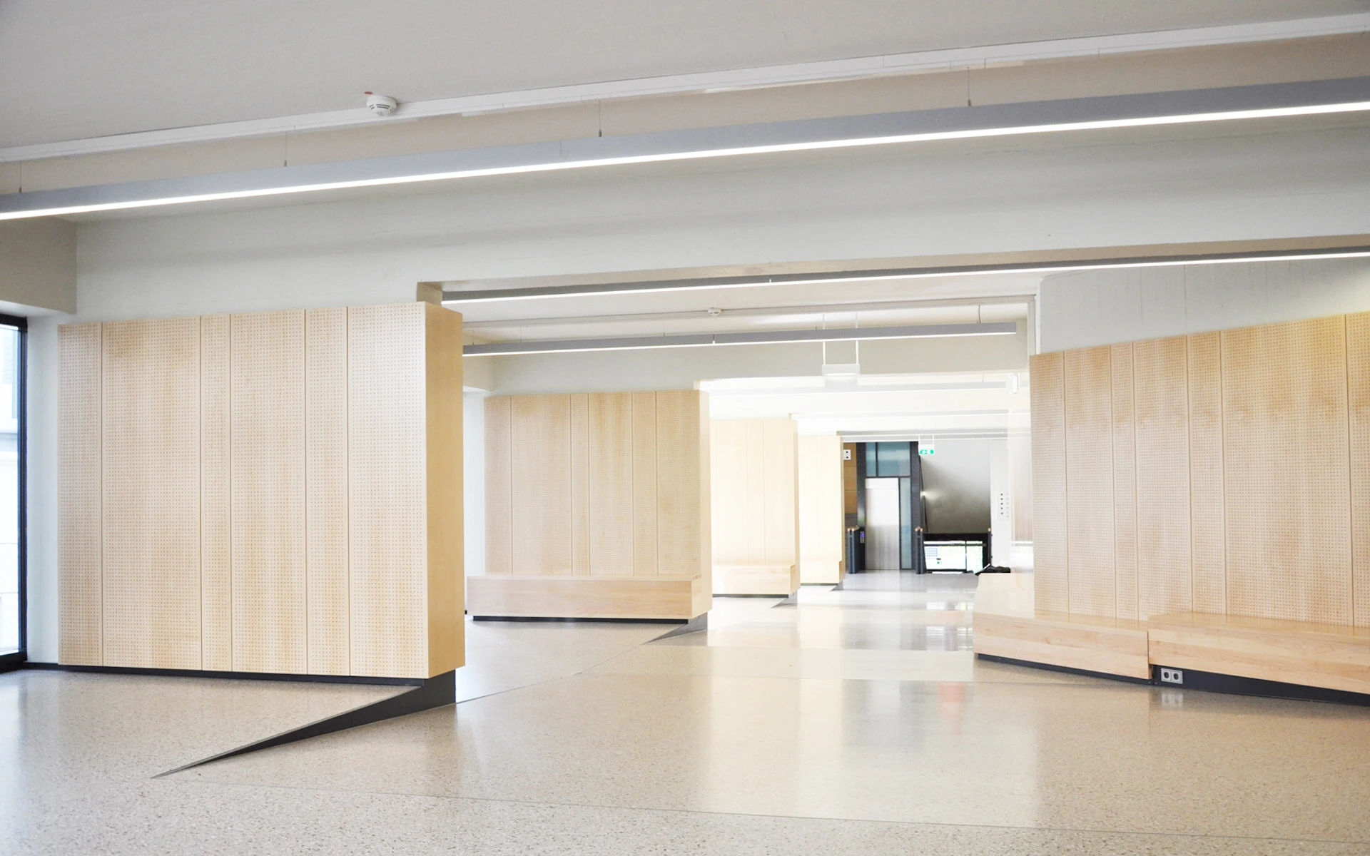 Umbau der Erschließung des Audimax und der Fachbibliothek Medizin des Universitätsklinikums Essen neugeschaffenes großzügiges Foyer mit Info-Lounges, Akustik-Holzvertäfelungen und Sitzgelegenheiten.