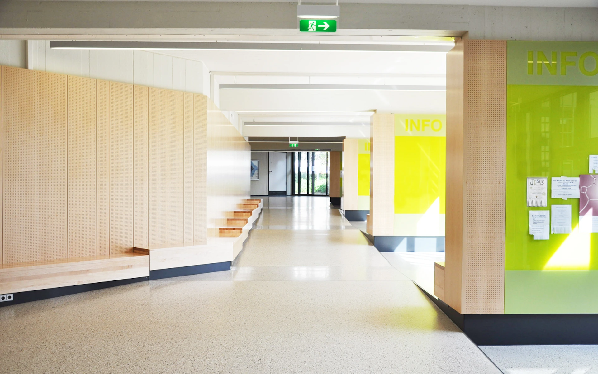 Umbau der Erschließung des Audimax und der Fachbibliothek Medizin des Universitätsklinikums Essen neugeschaffenes großzügiges Foyer mit Info-Lounges, Akustik-Holzvertäfelungen, Sitzgelegenheiten und farbigen Infotafeln.