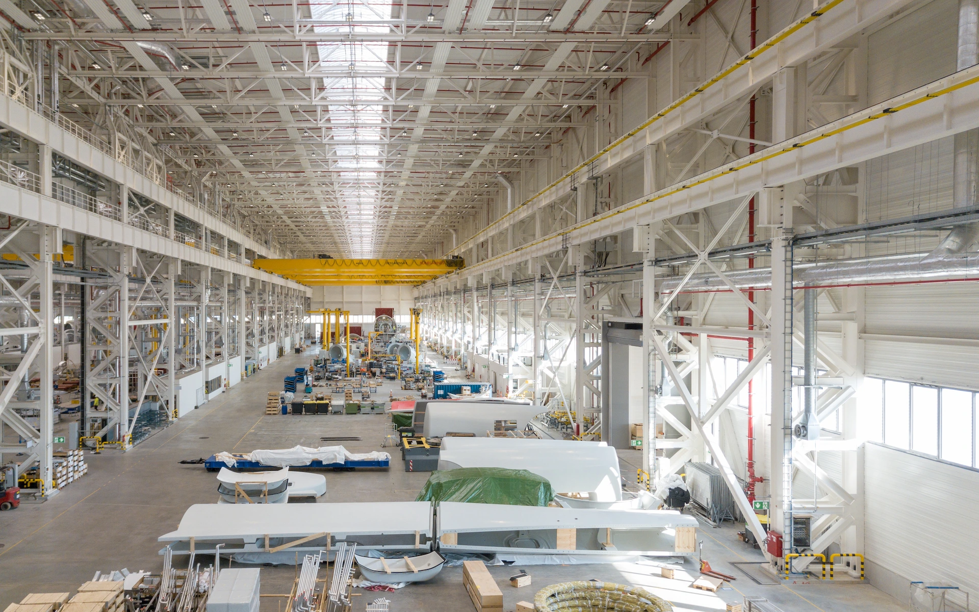 Neubau Siemens Windturbinen Fabrik in Cuxhaven als Innenraumaufnahme mit Schwerlast-Produktionsflächen, Nebenraumeinbauten, Krananlagen in zwei Ebenen, Lichtbändern und natürlich belichteter Halle.