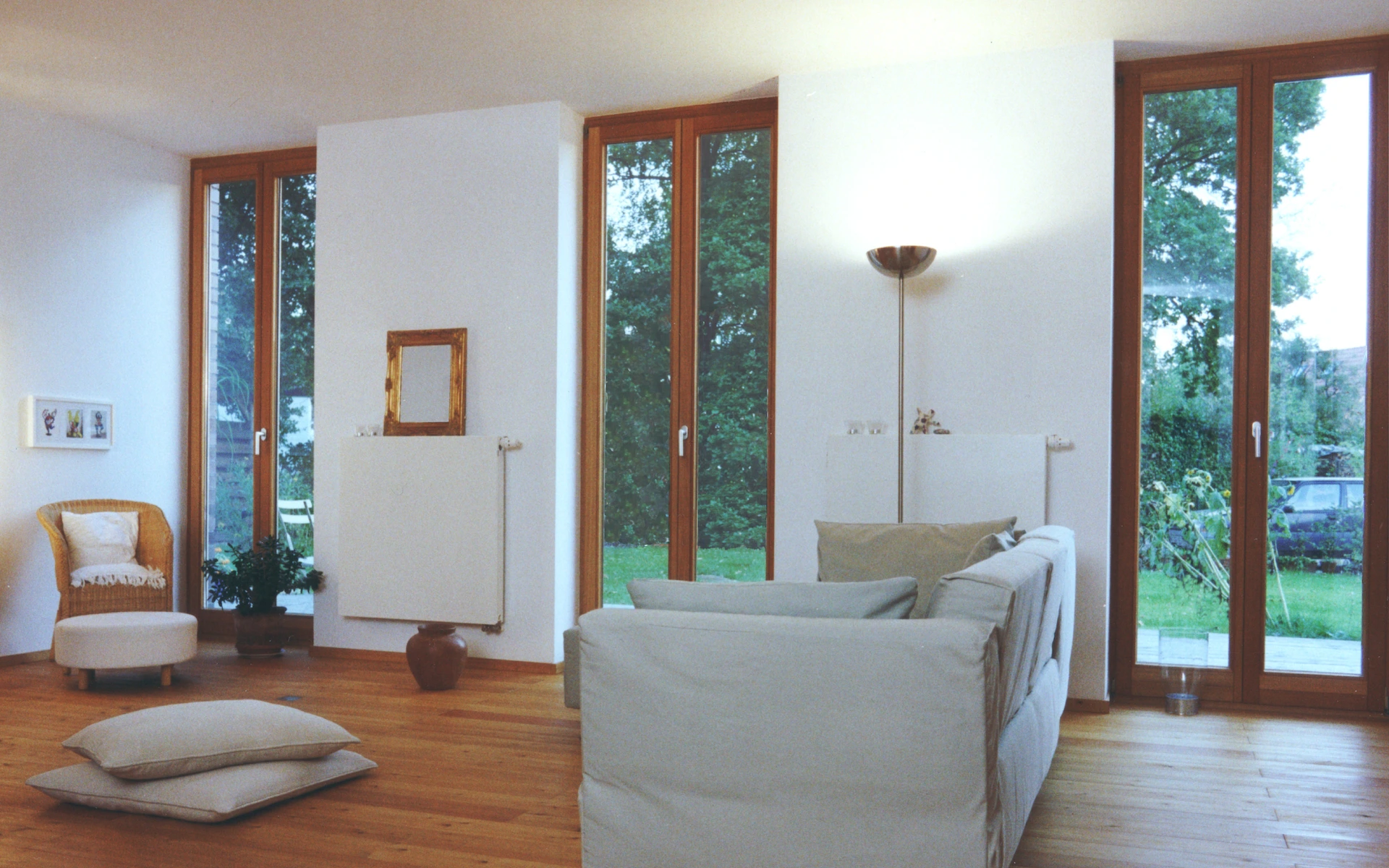 Neubau Haus A in Edewecht Wohnzimmer mit französischen Fenstern und Dielenboden auf Lagerhölzern.