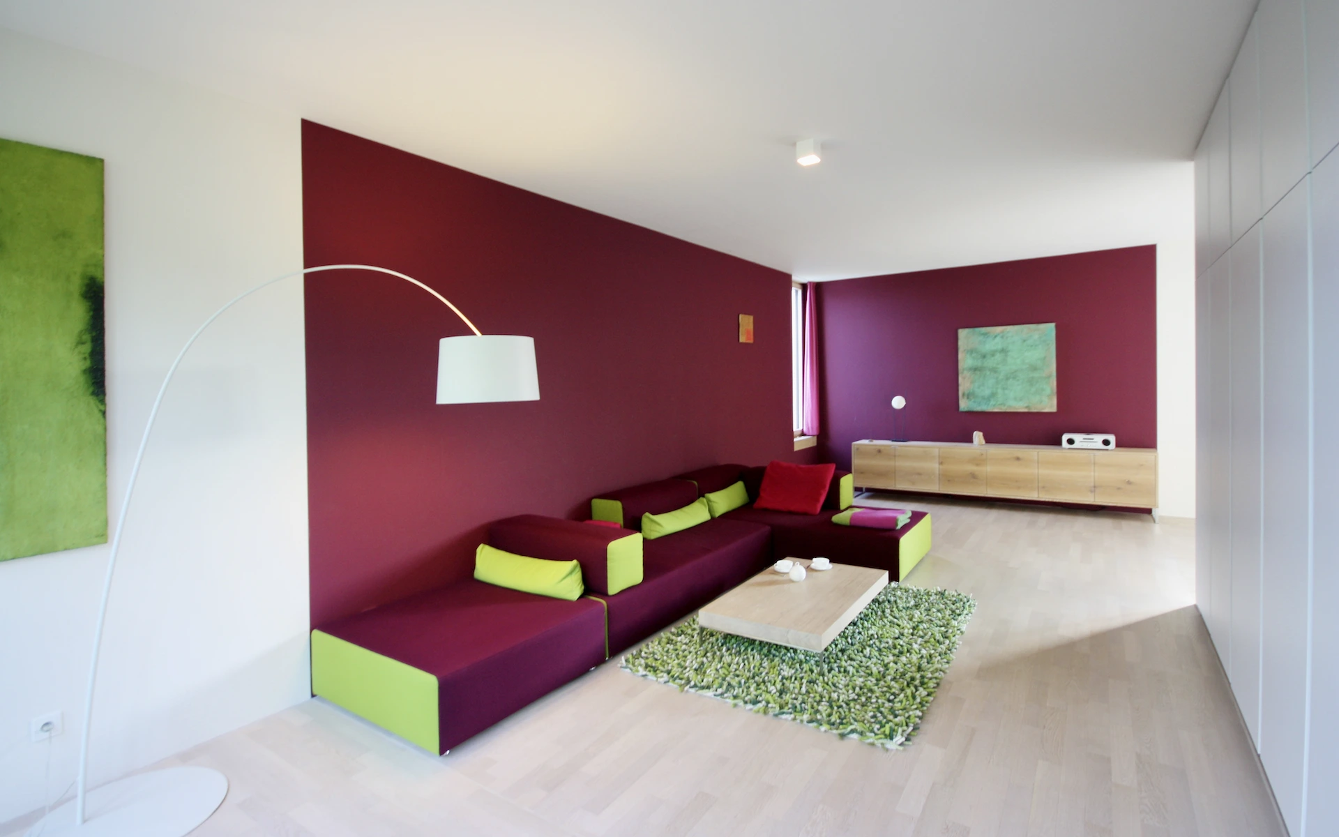 Neubau Haus R in Velbert-Langenberg Wohnbereich mit farbiger Wandgestaltung, weiß geöltem Eichenparkett, Einbauschränken und Kunst von Thomas Kesseler.