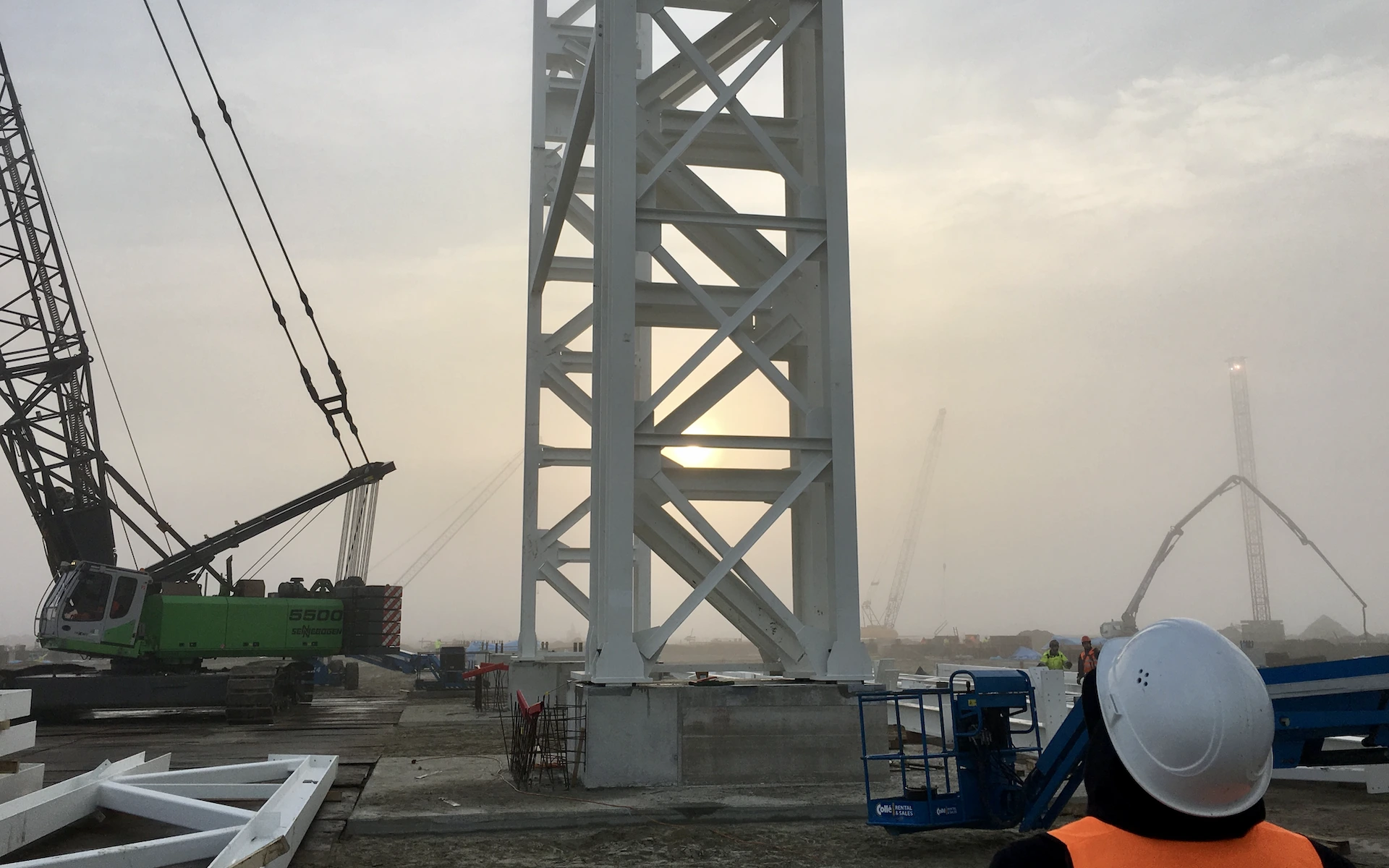 Baustelle Neubau Siemens Windturbinen Fabrik in Cuxhaven mit Baufeld, großer Doppel-Fachwerk-Stütze und Kranarbeiten.