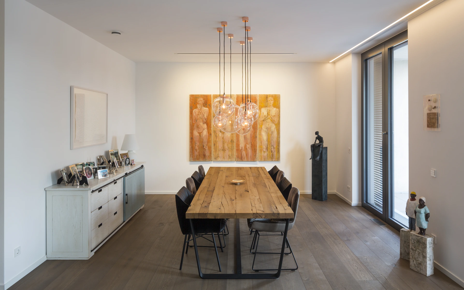 Neubau Haus K in Kamp-Lintfort Esszimmer mit französischem Fenster, elektrischem Schiebeladen, großformatigen Parkettdielen und Kunstgegenständen.
