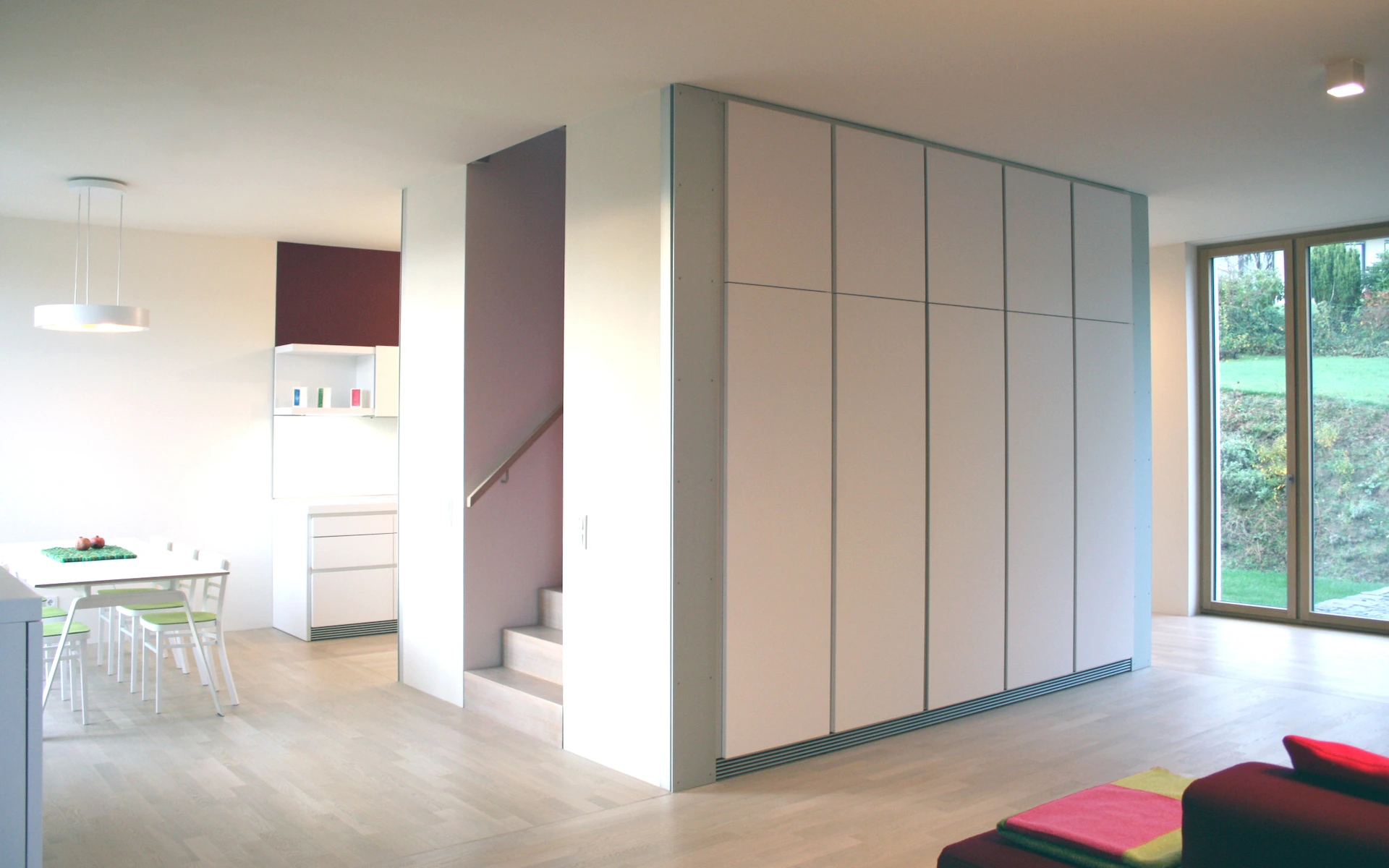 Neubau Haus R in Velbert-Langenberg Wohn- und Essbereich mit eingestellter Treppe mit begleitenden Einbauschränken, raumhohen Holz-Aluminium-Fenstertüren und weiß geöltem Eichenparkett.