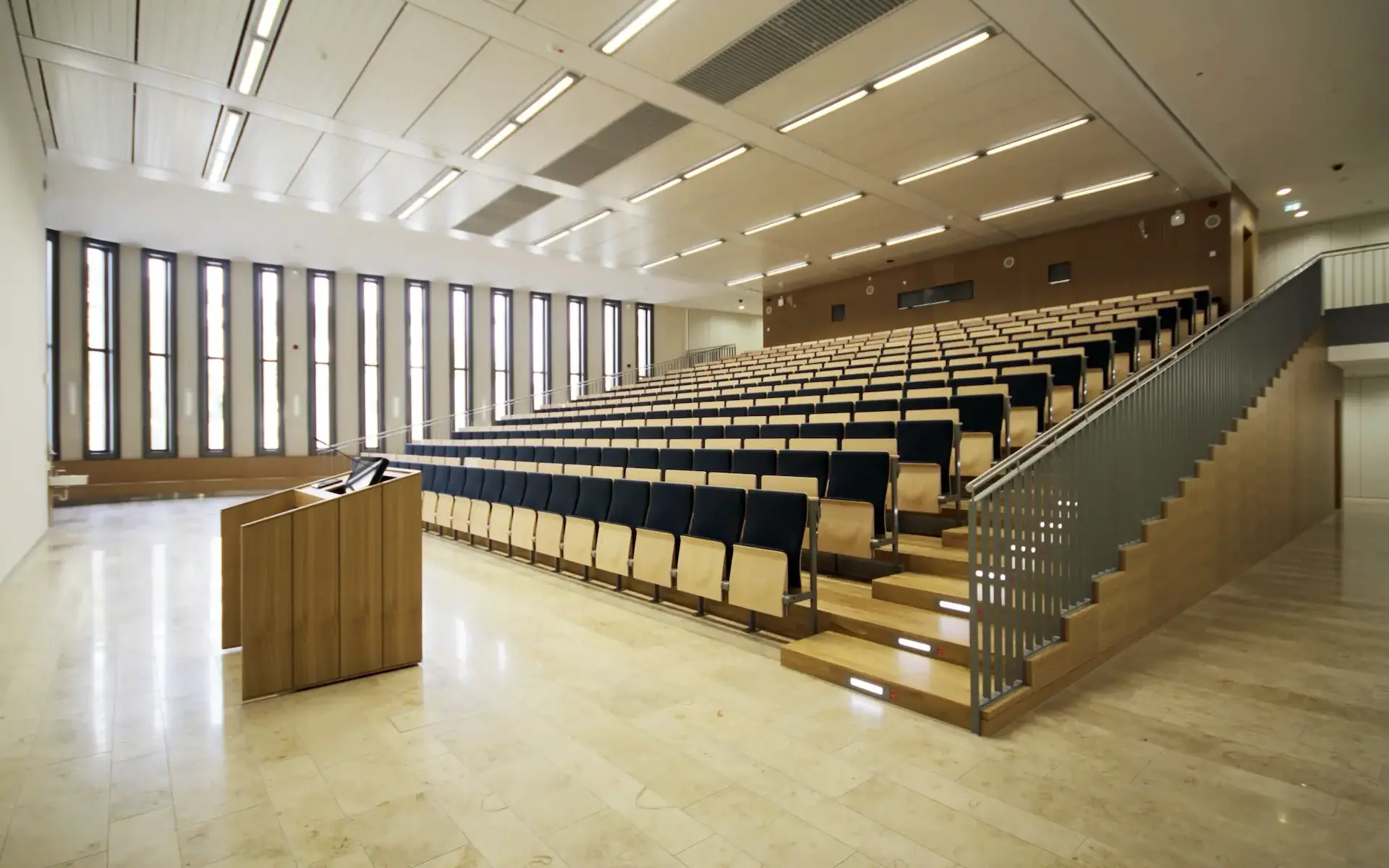 Neubau Lehr- und Lernzentrum des Universitätsklinikums Essen Innenraum des Auditoriums oder großen Hörsaals mit ansteigendem Gestühl und vertikalen raumhohen Fensterschlitzen.