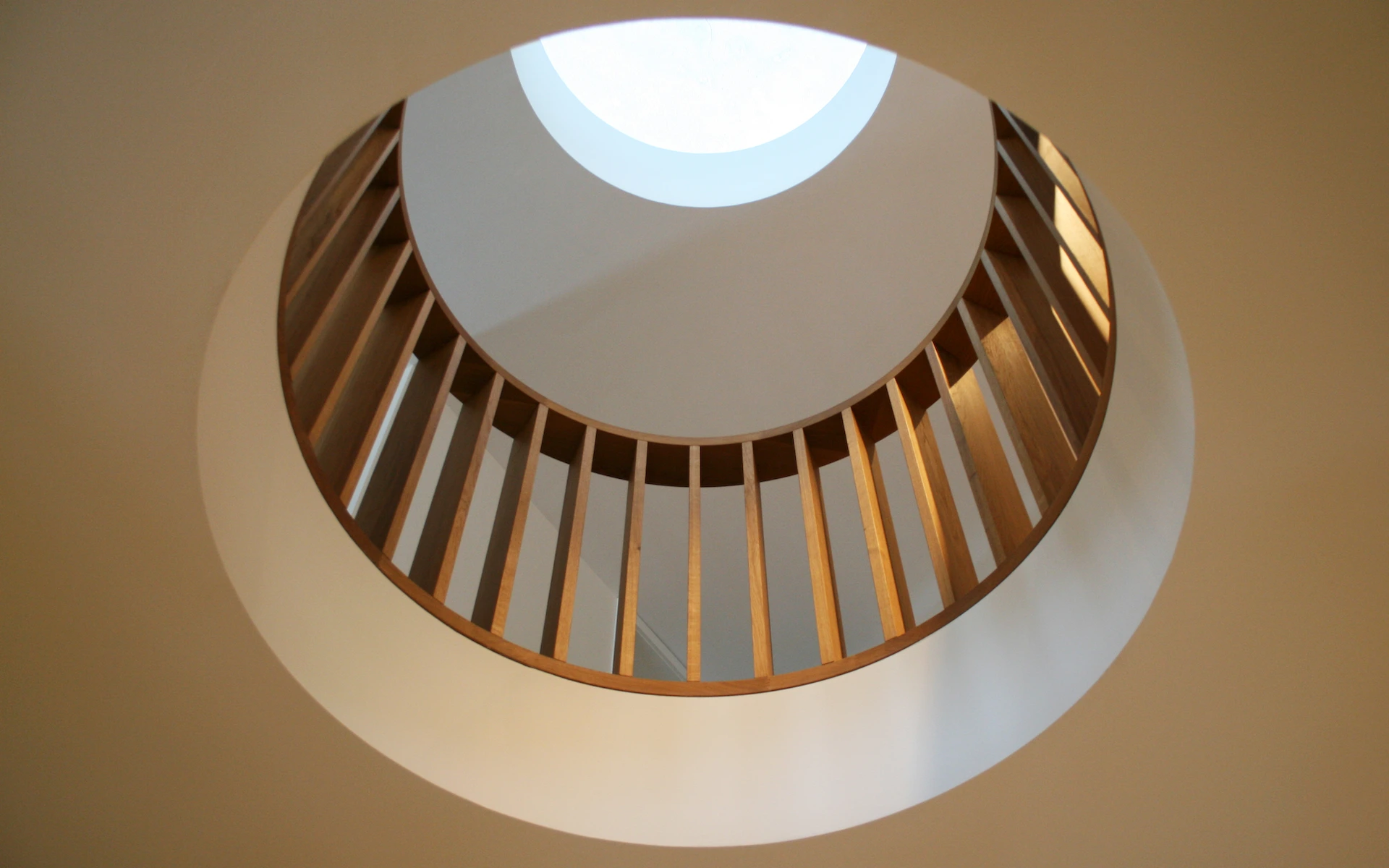 Neubau Haus D in Bochum kreisrunde Öffnung zur Galerieebene mit Holzgeländer und Oberlicht.
