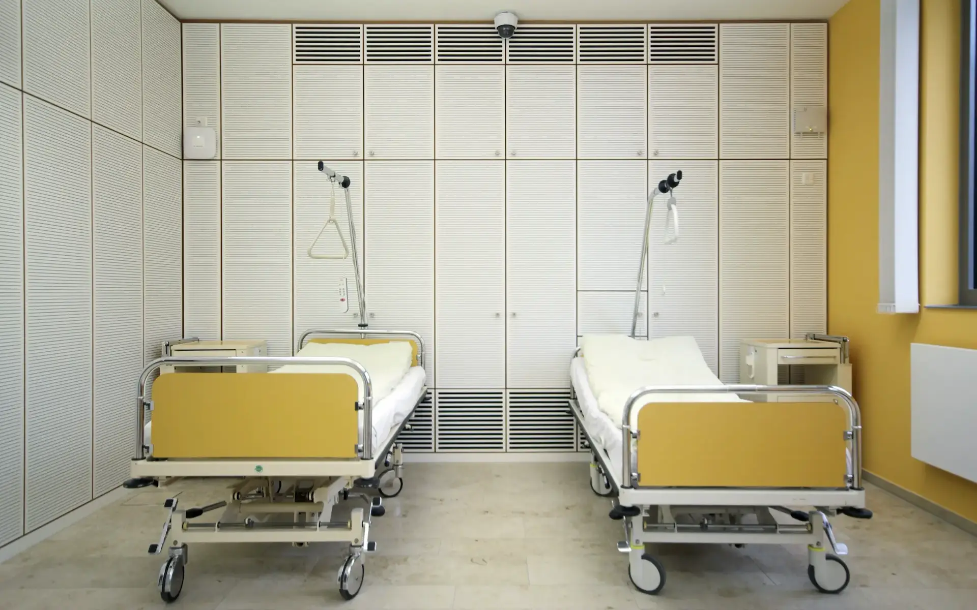 Das Bild zeigt den Neubau des Lehr- und Lernzentrum in Essen. Abgelichtet ist ein Exemplarischer Seminarraum der als Simulationsraum für Behandlungszimmer im Klinikalltag dient. Er ist belegt mit 2 einzelnen Krankenhausbetten sowie von einer Raumhohen Schrankwand eingefasst.